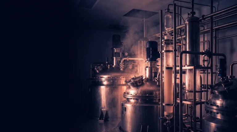 Interior de una planta farmacéutica de fabricación de péptidos con reactores de acero y columnas de cromatografía en tono salmón, que ilustra la escala industrial de los GLP-1.