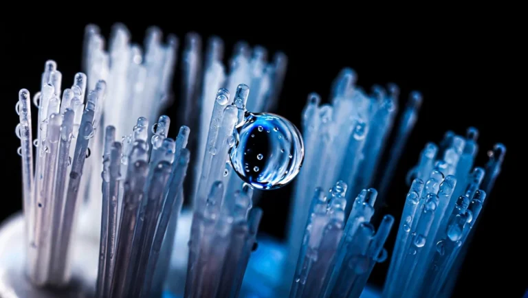 Macrofotografía de cerdas de cepillo dental con una gota de agua suspendida, higiene bucal como base de la prevención cardiovascular según evidencia 2026.