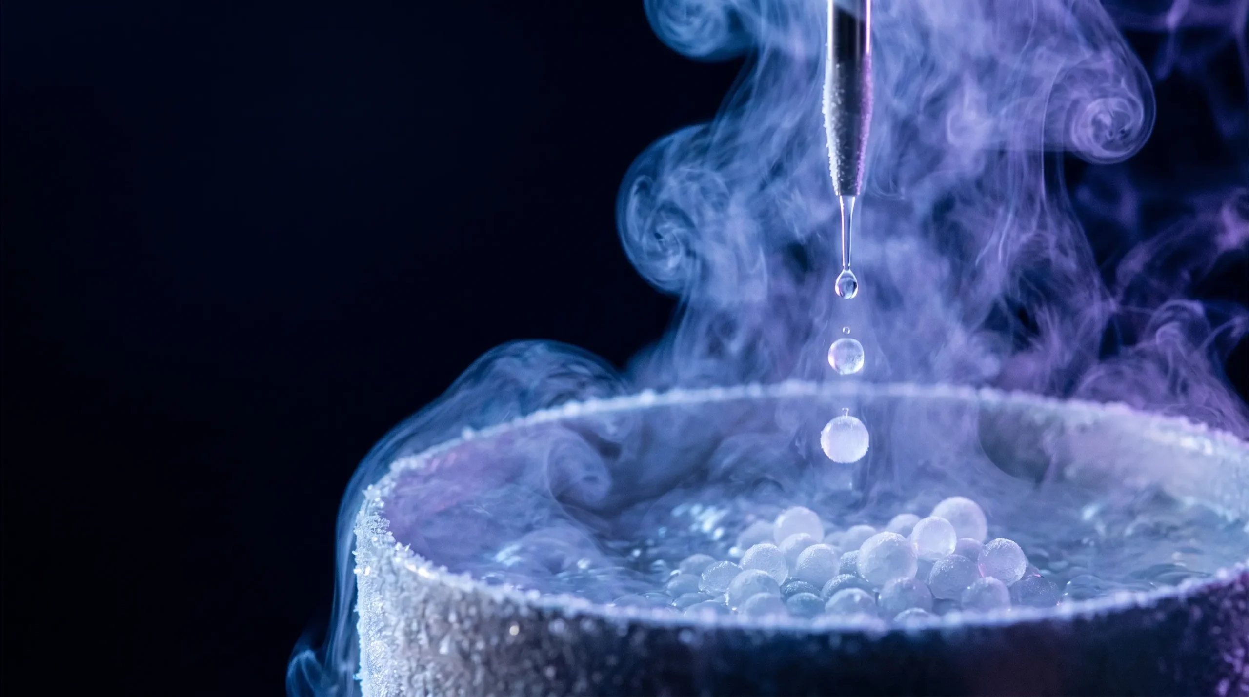 Gotas de una solución de péptido caen en un baño de nitrógeno líquido y se congelan en pequeñas perlas heladas entre vapor criogénico, el primer paso para fabricar lyobeads.